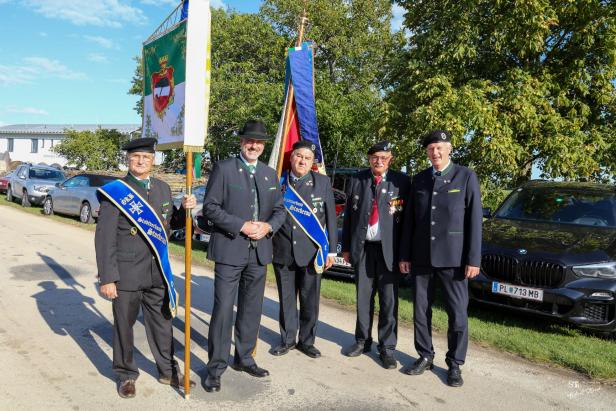 Fünf Männer in Tracht posieren mit Fahnen in Großharras.