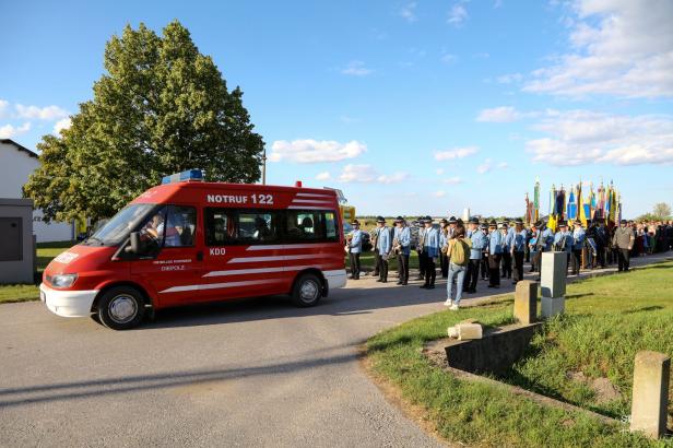 Ein Festumzug in Großharras mit einem roten Feuerwehrwagen und einer Musikkapelle.