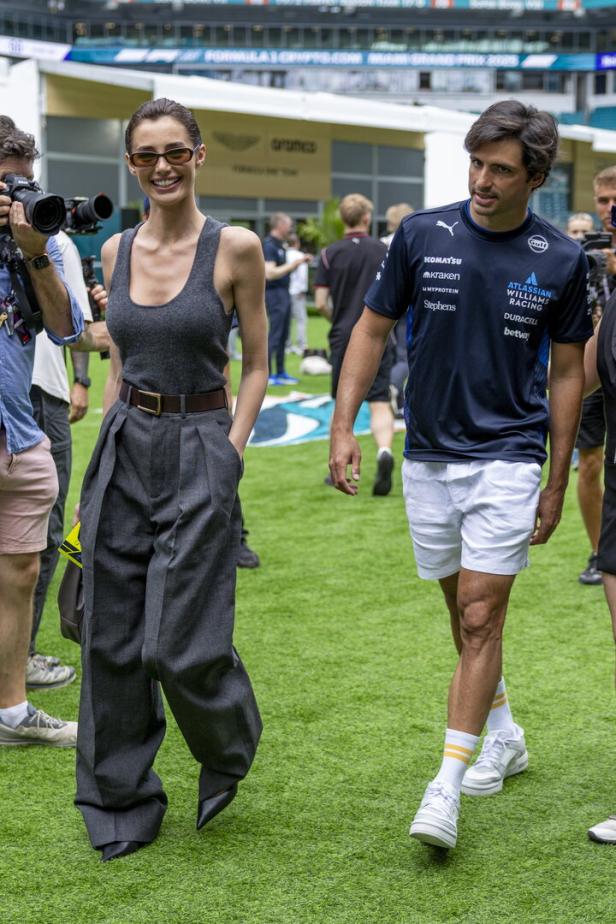Eine Frau und ein Mann gehen beim Formel-1-Grand-Prix von Miami über den Rasen.