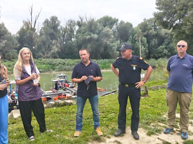 Eine Gruppe von Personen steht am Ufer eines Flusses in Marchfeld, Slowakei.