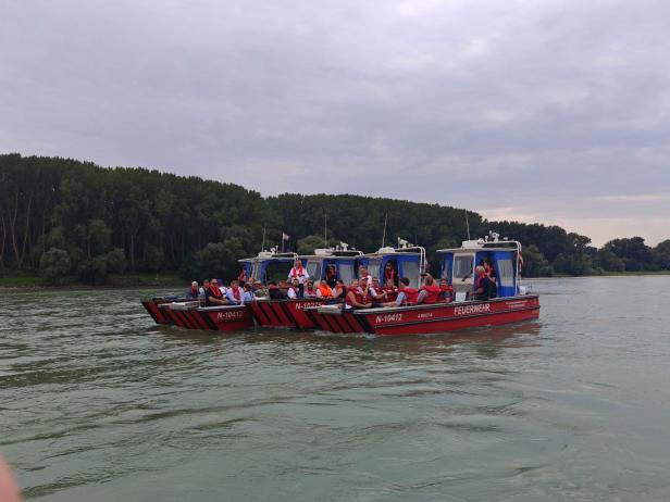 Drei Feuerwehrboote mit Passagieren auf einem Fluss in der Nähe von Marchfeld und der Slowakei.