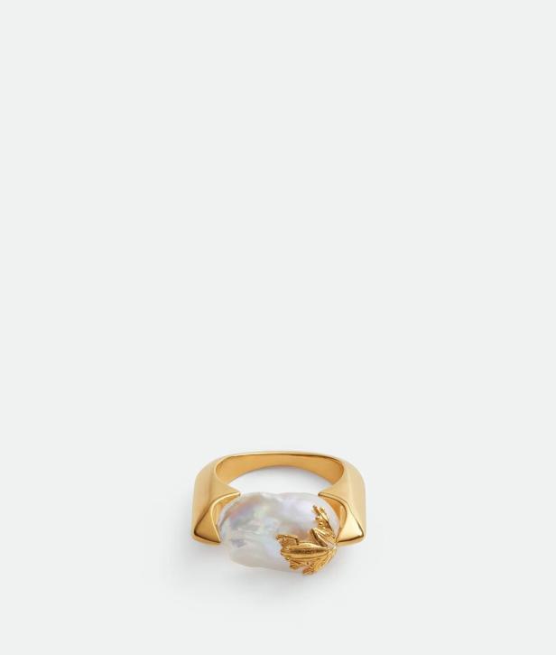 Ein goldener Ring mit einer großen, unregelmäßigen Perle und einem goldenen Frosch.