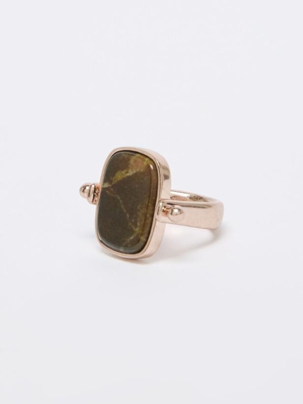 Ein goldfarbener Ring mit einem rechteckigen, braun-grün marmorierten Stein.