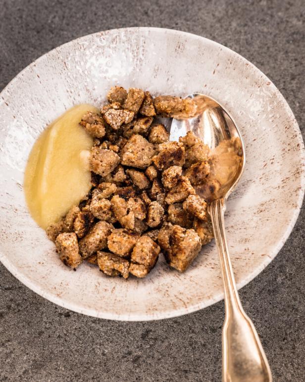 Teller mit gebratenen Brotwürfeln und Apfelmus, dazu ein Löffel.
