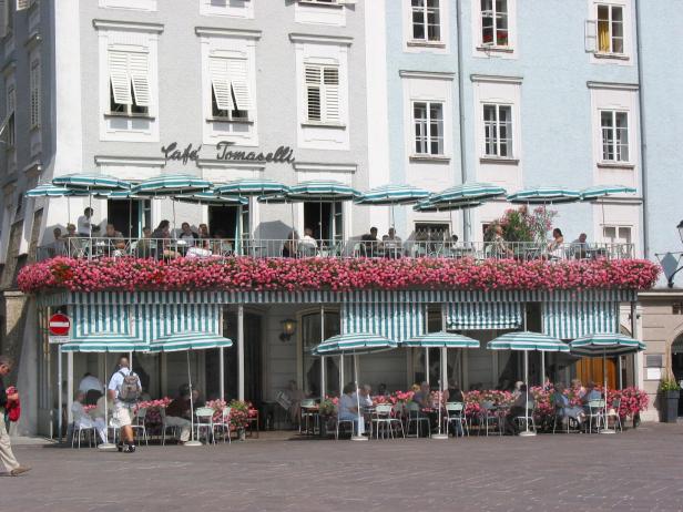 Das Café Tomaselli mit Gästen auf der Terrasse und im Außenbereich.