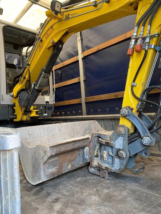 Ein gelber Bagger in einem Lkw.