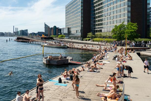 Menschen sonnen sich an einem sonnigen Tag auf der Kalvebod Welle in Kopenhagen.