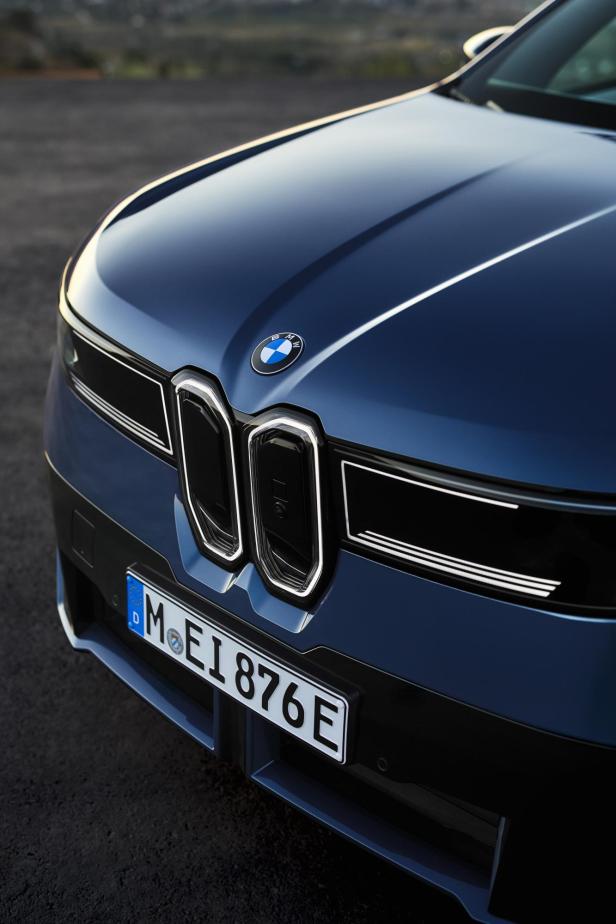 Detailaufnahme des neuen blauen BMW iX3 von vorne mit BMW-Logo.