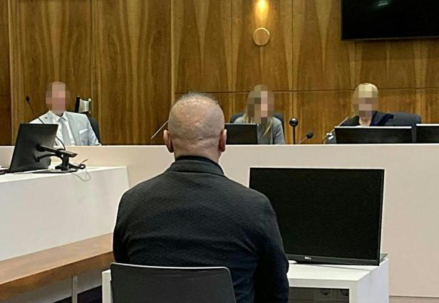 Angeklagter Mann von hinten vor Richtertisch