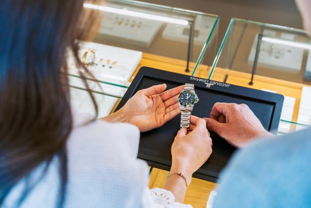 Jacques Lemans Uhrenkauf Eine Dame hält eine Uhr in der Hand und betrachtet sie