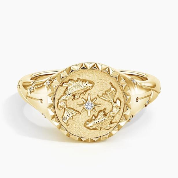 Ein goldener Siegelring mit dem Sternzeichen Fische und einem Diamanten.