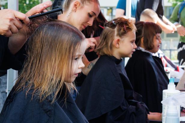 Kleine Mädchen bekommen einen Haarschnitt.