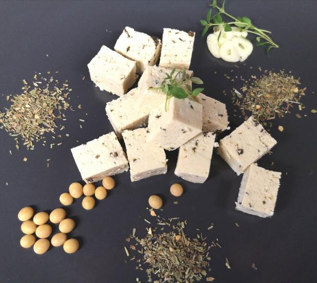 In Würfel geschnittener Tofu aus dem Waldviertel auf einem dunklen Teller schön garniert.