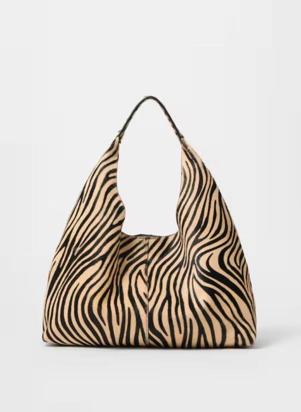 Eine Handtasche mit Zebramuster vor einem weißen Hintergrund.
