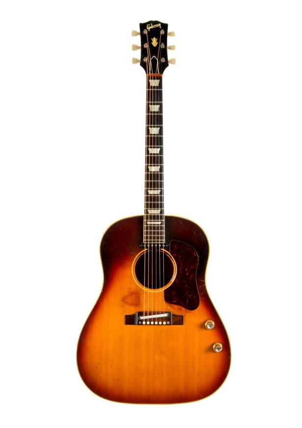 Eine akustische Gibson-Gitarre mit einem rotbraunen Schlagbrett vor einem weißen Hintergrund.