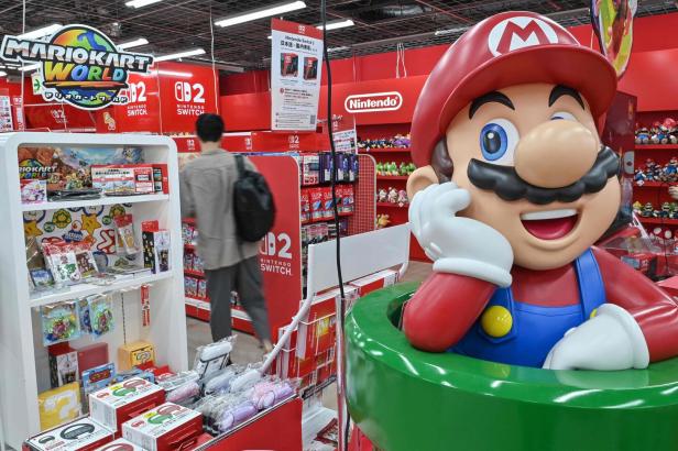 Eine große Mario-Figur in einem Nintendo-Geschäft in Japan, mit „Mario Kart“-Artikeln im Hintergrund.