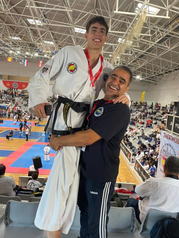 Mattiullah Karwandgar hält seinen Sohn Adam nach seinem Sieg in der Sporthalle in die Luft.