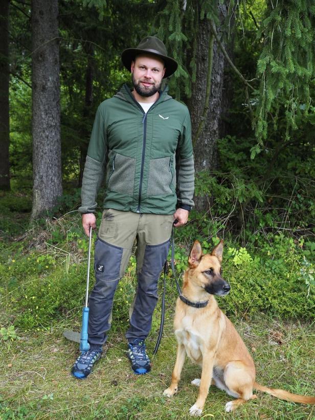 Mann hält Hund an der Leine