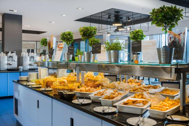 Ein Buffet mit einer Vielzahl von Speisen, darunter Salate, Hauptgerichte und Desserts, ansprechend angerichtet.