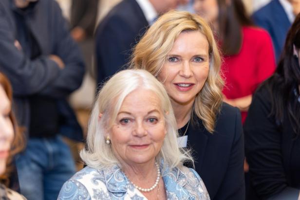 Zwei Frauen posieren lächelnd für ein Foto. Zwei Frauen posieren lächelnd für ein Foto.