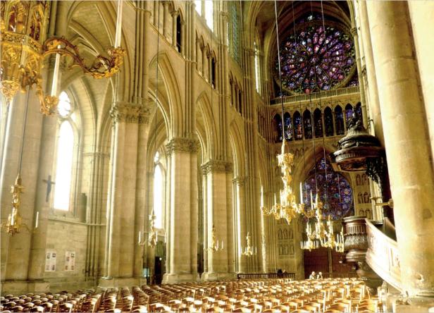 Innenraum der Kathedrale mit vielen Säulen und einem Rosettenfenster.