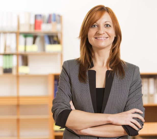 Nina Sillipp steht mit verschränkten Armen vor einem Bücherregal. Nina Sillipp steht mit verschränkten Armen vor einem Bücherregal.