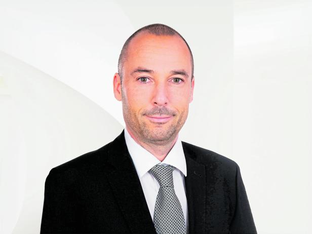 Roland Schatz in einem schwarzen Anzug mit Krawatte. Roland Schatz in einem schwarzen Anzug mit Krawatte.