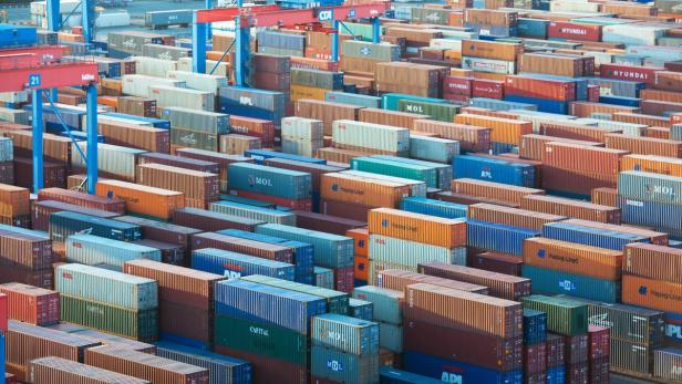 Container: Export als Eckpfeiler der deutschen Wirtschaft. Viele bunte Frachtcontainer stapeln sich auf einem Containerterminal.
