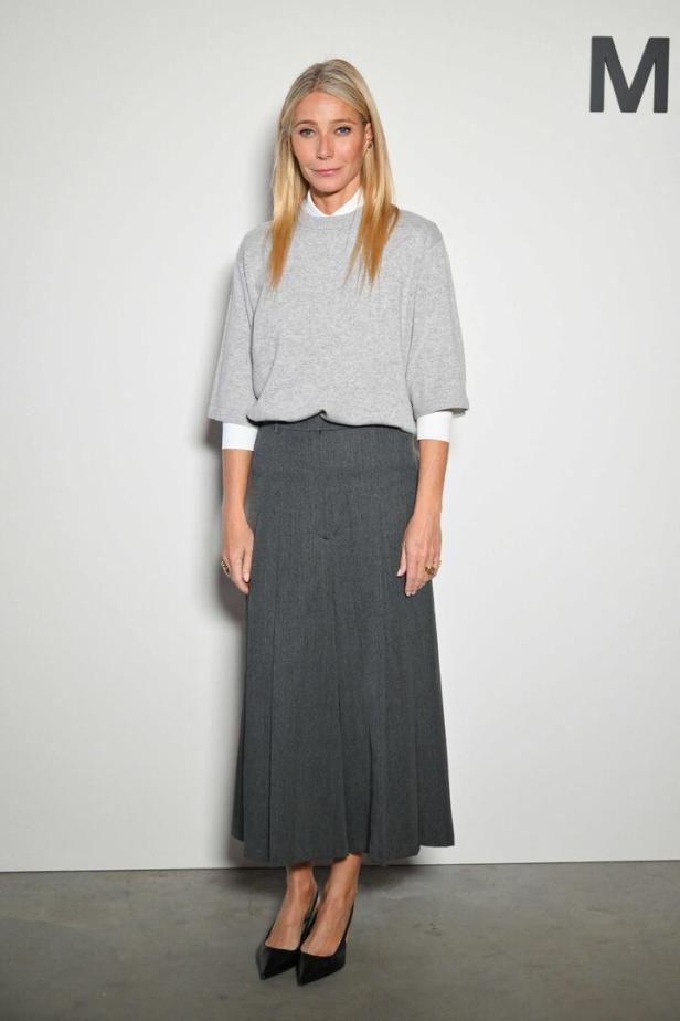 Gwyneth Paltrow trägt einen grauen Pullover und einen langen Rock.