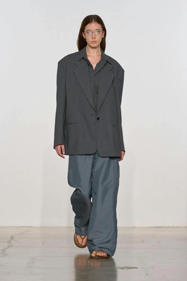Model mit übergroßem Blazer und weiten Hosen in Grau.
