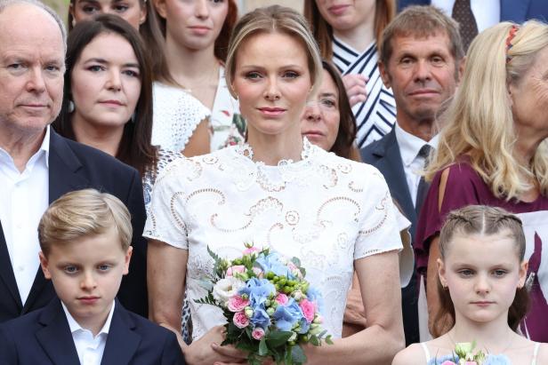 MONACO-ROYALS-TRADITION Charlene in weißer Spitzenkleidung hält einen Blumenstrauß, umgeben von Albert und ihren Kindern.