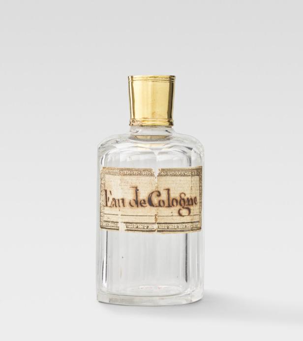 Eine Flasche Eau de Cologne mit goldenem Verschluss und einem Etikett.