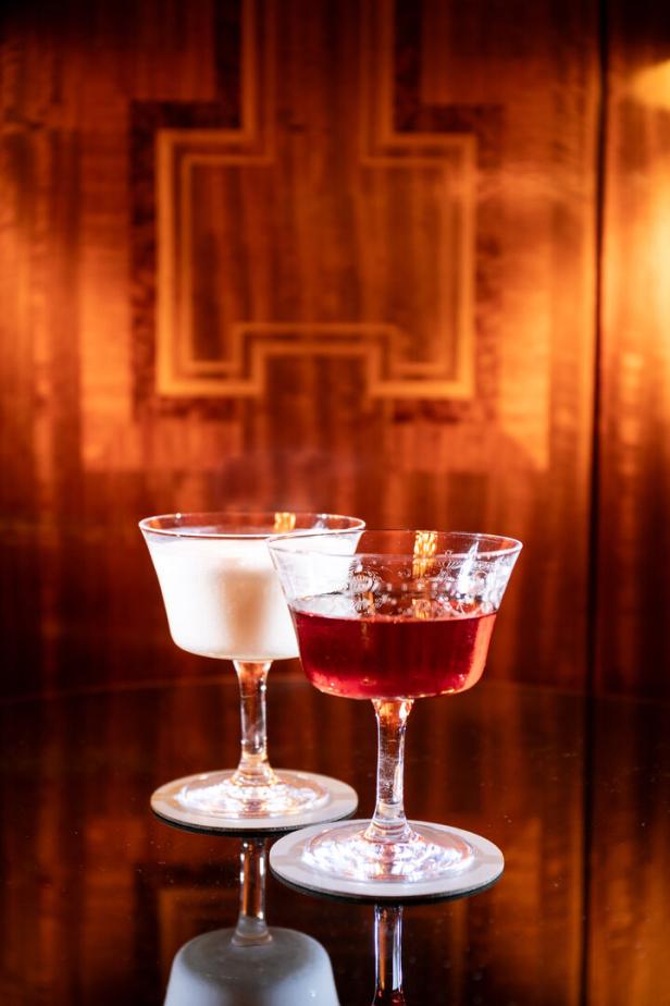 Zwei Cocktails, einer weiß und einer rot, stehen auf einem Tisch.