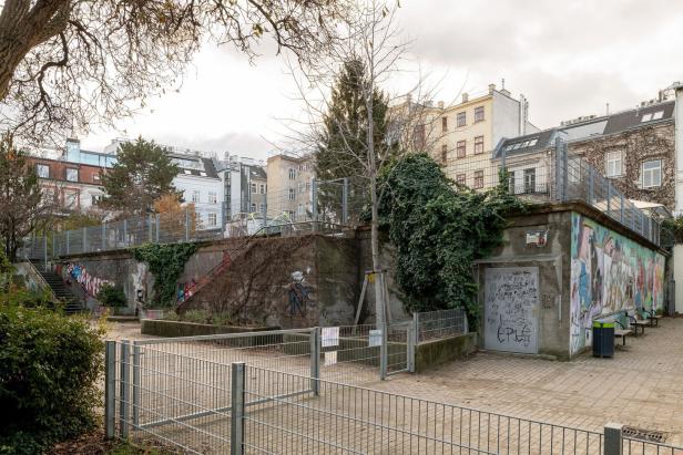 Ein öffentlicher Platz mit Graffiti-Wänden und Treppen in einer städtischen Umgebung.
