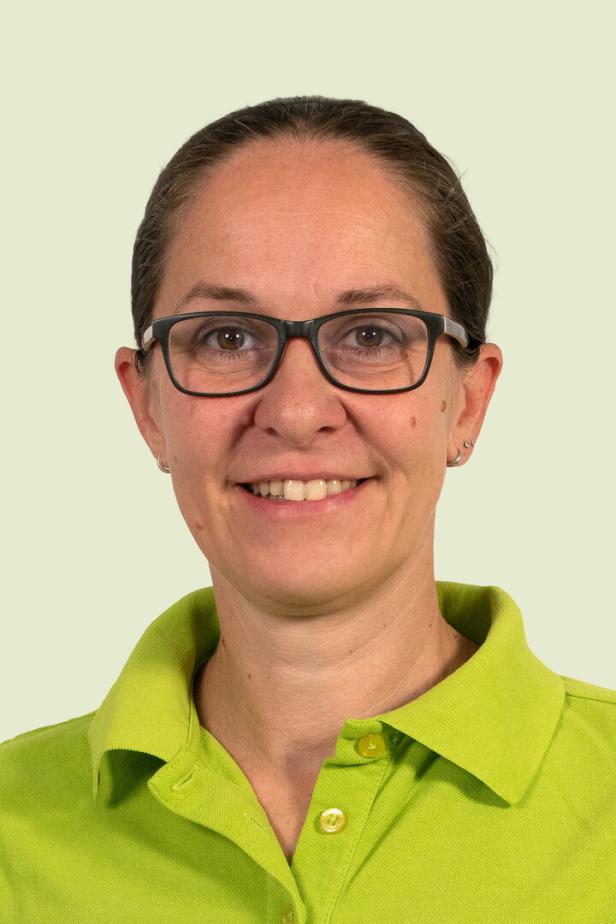 Porträt von Andrea Hiemetzberger mit Brille und grünem Poloshirt.