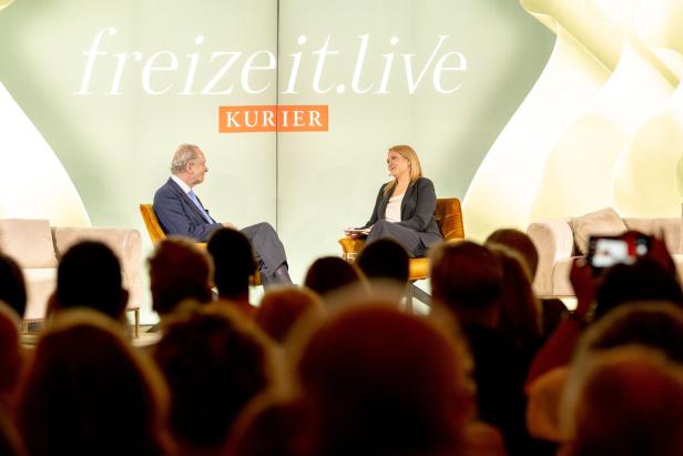 Ein Mann und eine Frau sitzen auf einer Bühne vor Publikum bei „freizeit.live“.