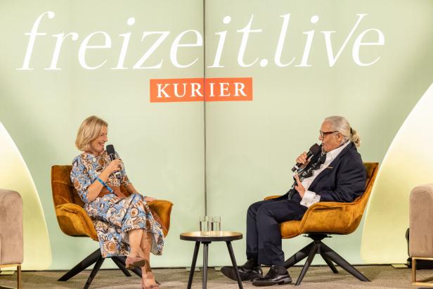 Zwei Personen sitzen auf Sesseln vor einem „freizeit.live“-Banner und sprechen in Mikrofone.