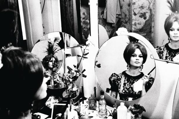Brigitte Bardot vor einem Spiegel beim Schminken.