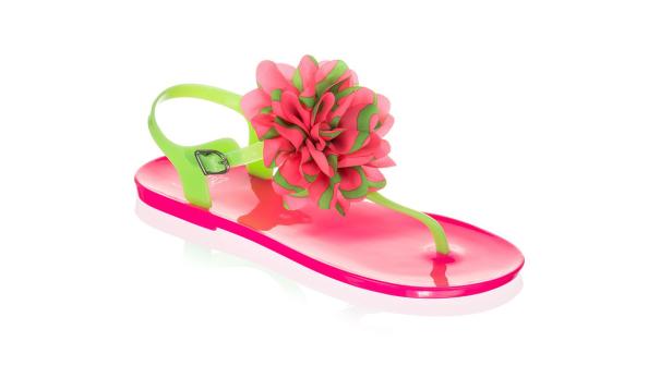 Eine pinke Sandale mit einer großen, dekorativen Blüte in Pink und Grün.