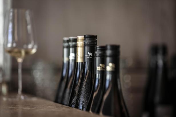 Mehrere Flaschen Weinviertel DAC Weine stehen auf einem Tisch.