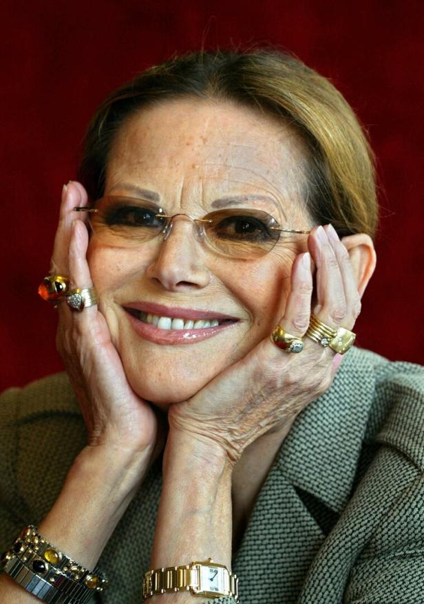 Frau mit Brille hält ihr Gesicht in den Händen und lächelt.