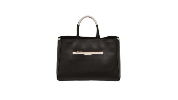 Eine schwarze Furla-Handtasche mit weißen Akzenten vor einem weißen Hintergrund.