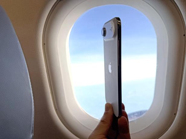 iPhone Air vor einem Flugzeugfenster