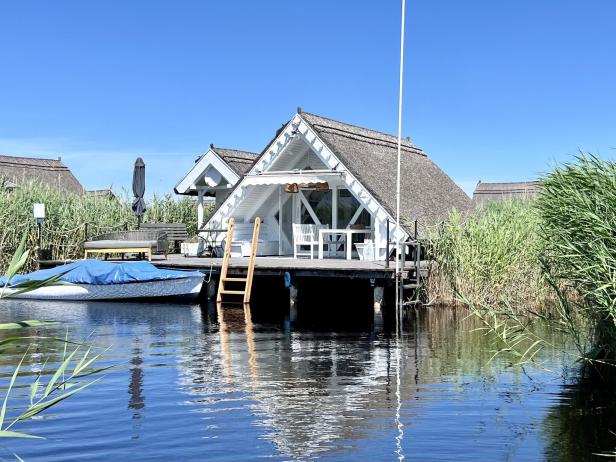 Seehütte direkt am Neusiedlersee mit Boot, das vor der Terrasse ankert