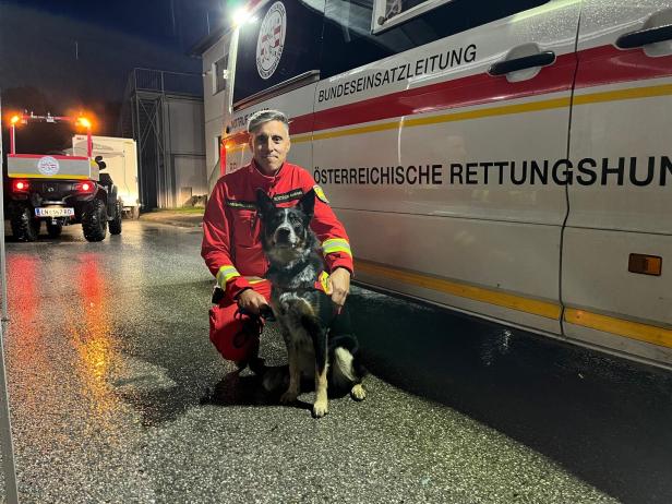 Ein Mann und ein Hund vor einem Rettungsfahrzeug.