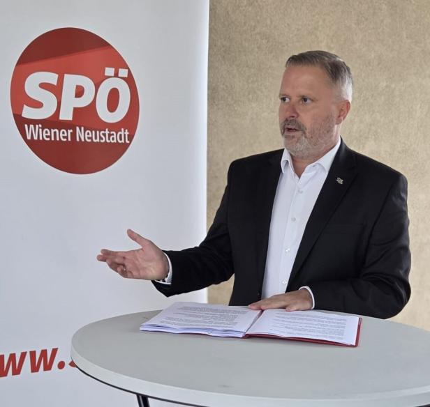 Mann vor einem SPÖ-Transparent