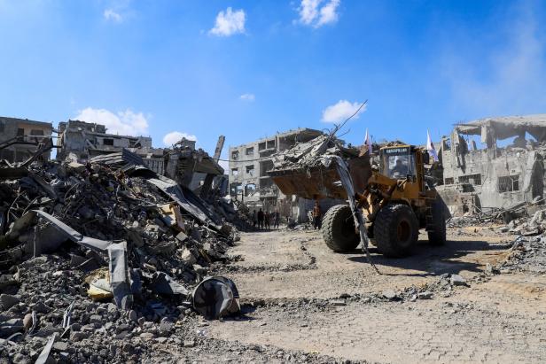 Heavy machinery removes debris from a street, amid a ceasefire between Israel and Hamas, in Gaza City
