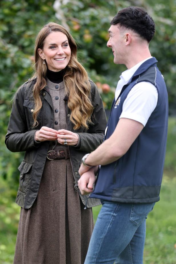 Prinzessin Kate PrinzessinKate unterhält sich lächelnd mit einem Mann im Freien.