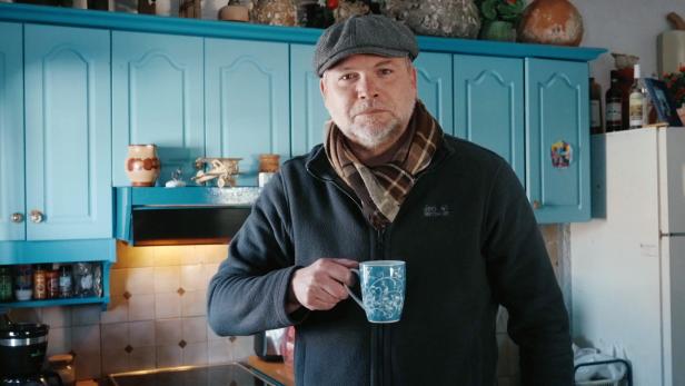 Mann mit Teetasse in Küche
