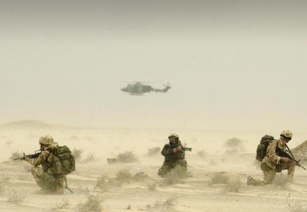 FILE PHOTO: Soldiers attached to Britain's 3 Army Air Corps patrol the desert around the oil fields of north Ramaila in Iraq